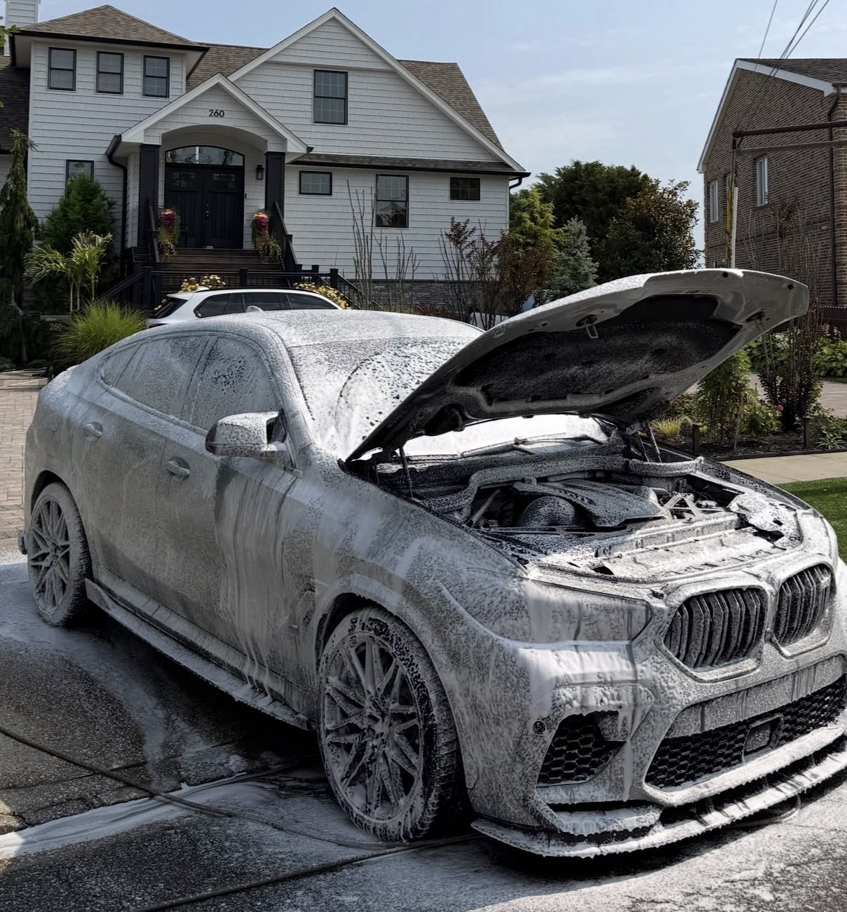 Silver performance SUV covered in foam during an exterior wash